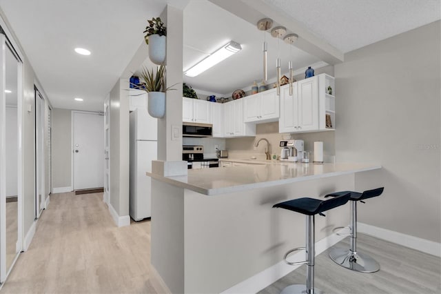 kitchen featuring light wood-type flooring, kitchen peninsula, electric range, white cabinetry, and white refrigerator