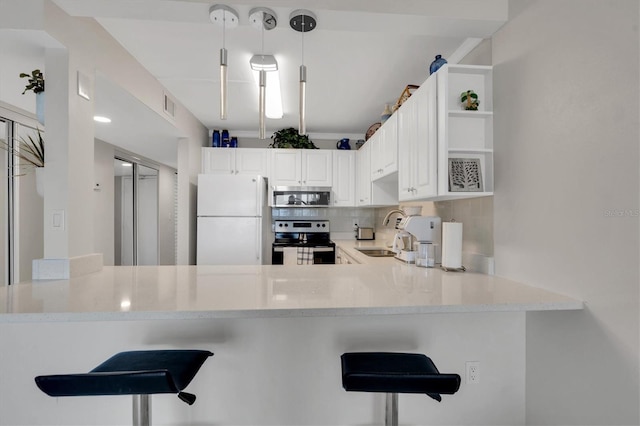 kitchen featuring white cabinets, backsplash, decorative light fixtures, stainless steel appliances, and kitchen peninsula