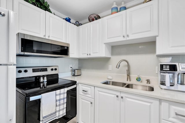 kitchen with white cabinets, sink, appliances with stainless steel finishes, and tasteful backsplash