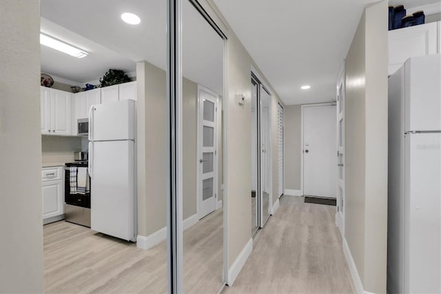 corridor with light hardwood / wood-style floors