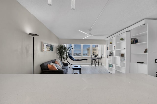 interior space with ceiling fan, light hardwood / wood-style flooring, and a textured ceiling