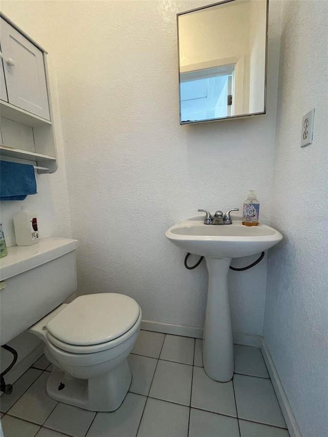 bathroom featuring tile flooring and toilet