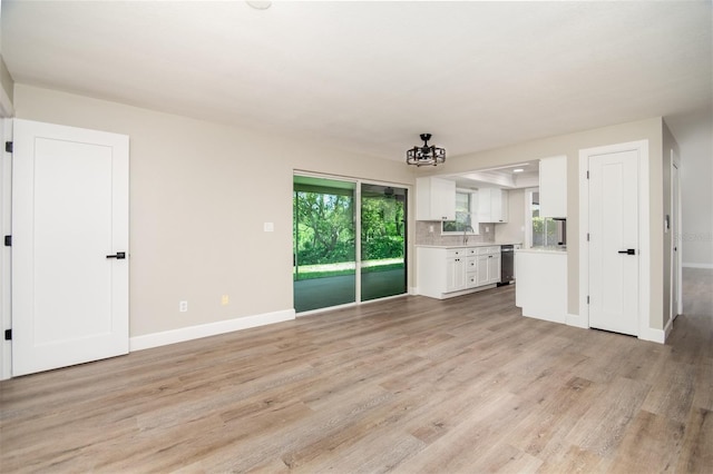 unfurnished living room featuring a wealth of natural light and light hardwood / wood-style flooring