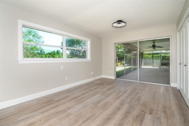 spare room with ceiling fan and light wood-type flooring