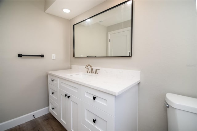 bathroom with toilet, hardwood / wood-style flooring, and large vanity