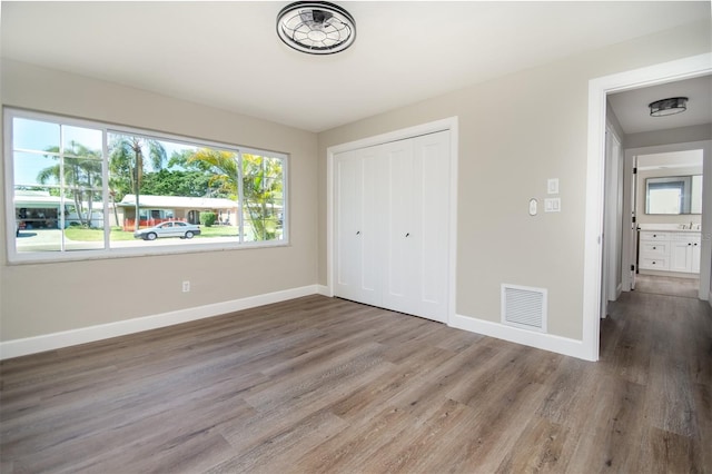 unfurnished bedroom featuring a closet and dark hardwood / wood-style floors