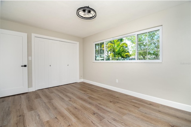 unfurnished bedroom featuring a closet and light hardwood / wood-style floors