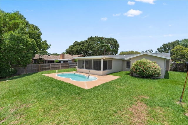 back of property with a sunroom, a fenced in pool, and a lawn