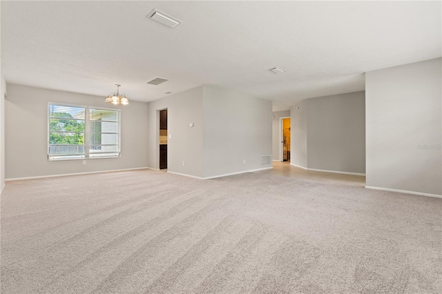 empty room featuring light carpet and an inviting chandelier