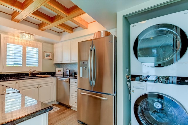 interior space featuring sink, stacked washer / drying machine, and light hardwood / wood-style flooring