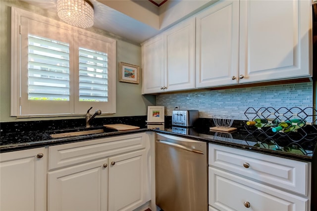 kitchen featuring white cabinets, dark stone countertops, tasteful backsplash, and stainless steel dishwasher