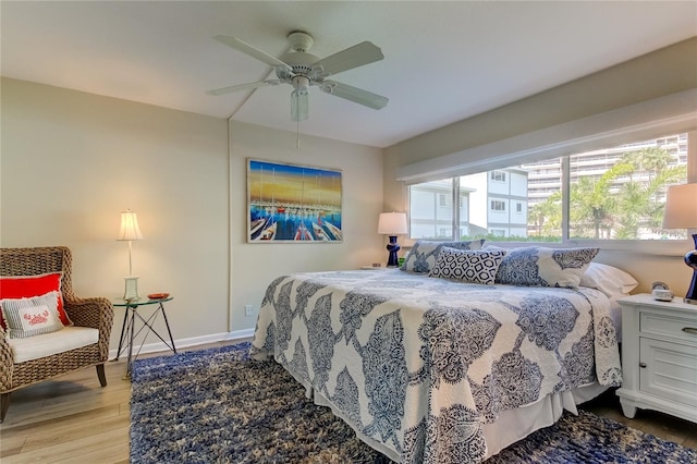 bedroom with hardwood / wood-style flooring, ceiling fan, and multiple windows