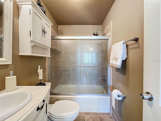 full bathroom with vanity, enclosed tub / shower combo, tile flooring, toilet, and a textured ceiling