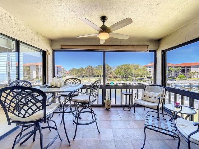 sunroom with a healthy amount of sunlight and ceiling fan