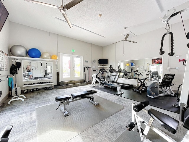 gym with french doors, a towering ceiling, ceiling fan, and a textured ceiling