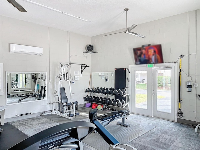 exercise room featuring a wall mounted AC, french doors, ceiling fan, and a textured ceiling