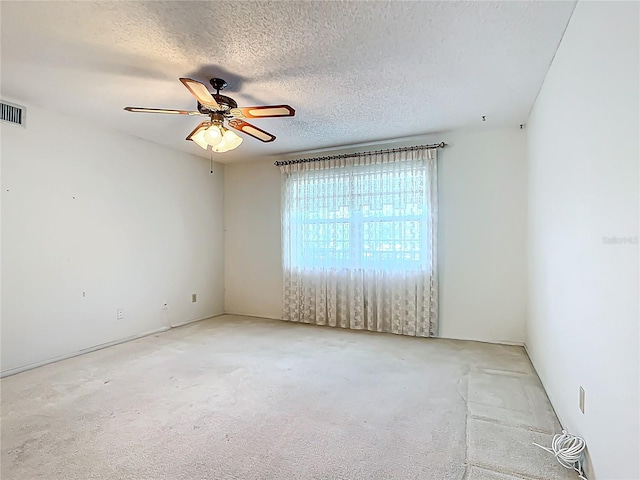 carpeted empty room featuring a textured ceiling and ceiling fan