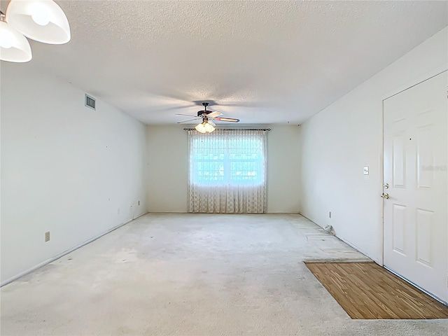 unfurnished room featuring ceiling fan, light hardwood / wood-style flooring, and a textured ceiling