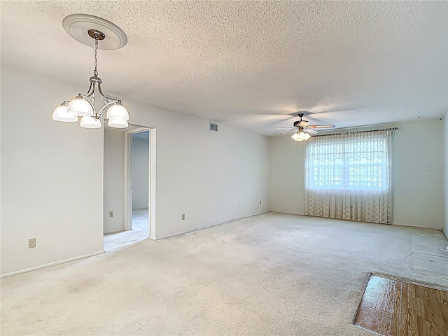 unfurnished room with ceiling fan with notable chandelier, carpet flooring, and a textured ceiling