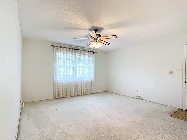 carpeted spare room with a textured ceiling and ceiling fan