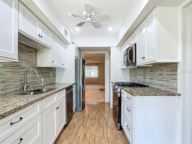 kitchen featuring ceiling fan, stainless steel appliances, light hardwood / wood-style floors, white cabinetry, and sink