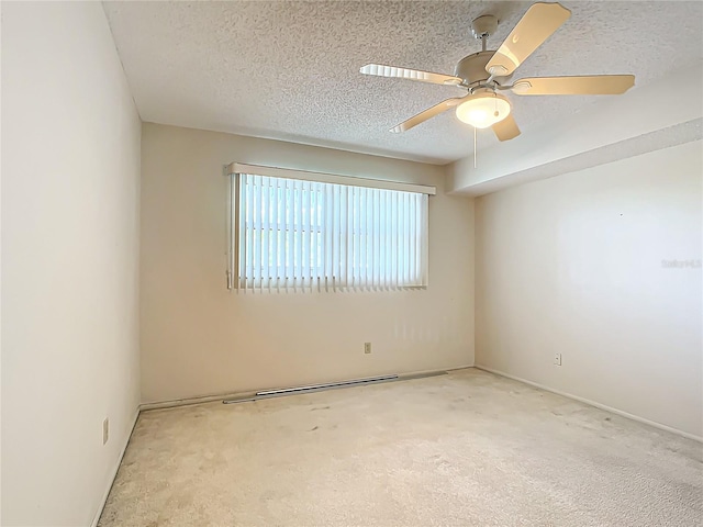 carpeted spare room featuring ceiling fan and a textured ceiling