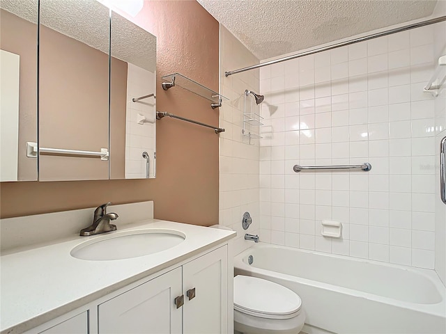 full bathroom with a textured ceiling, vanity, toilet, and tiled shower / bath