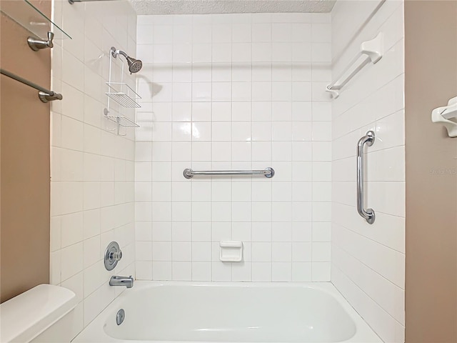 bathroom with tiled shower / bath and toilet