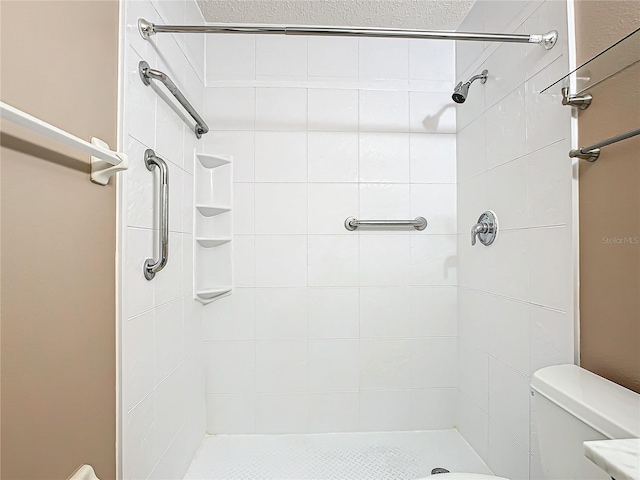 bathroom with tiled shower and toilet