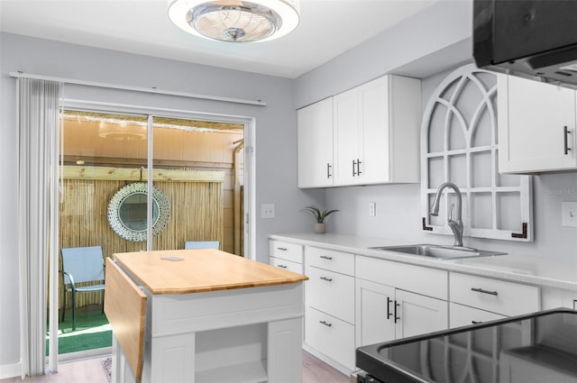 kitchen featuring white cabinets, sink, light hardwood / wood-style flooring, and a center island