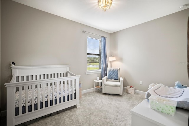 bedroom featuring light colored carpet and a nursery area