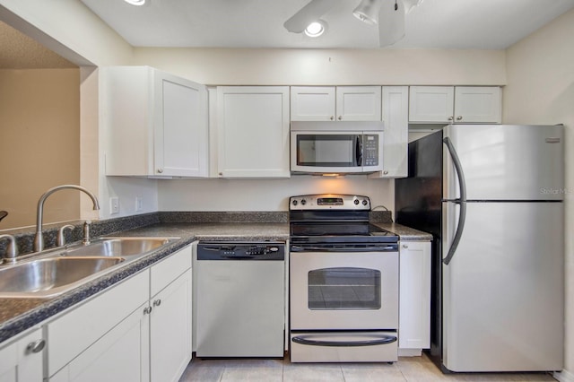 kitchen featuring white cabinets, sink, stainless steel appliances, and light tile floors