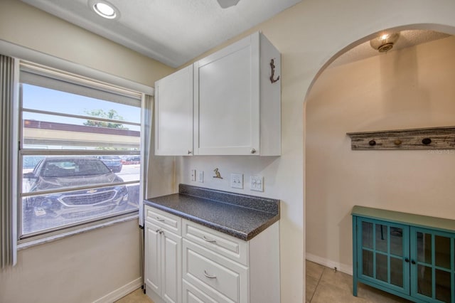 kitchen with light tile floors and white cabinetry