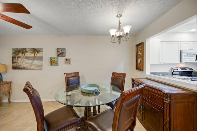 dining space featuring light tile flooring, ceiling fan with notable chandelier, and a textured ceiling