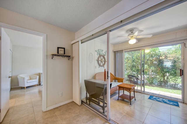 interior space with ceiling fan and light tile floors