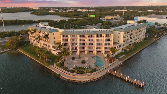 aerial view at dusk featuring a water view