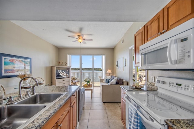 kitchen with white appliances, sink, ceiling fan, a textured ceiling, and light tile patterned flooring