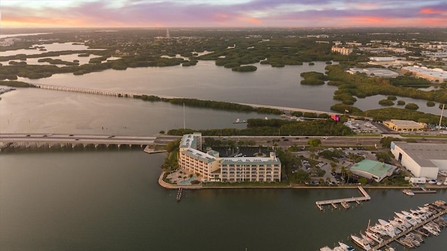 aerial view at dusk featuring a water view