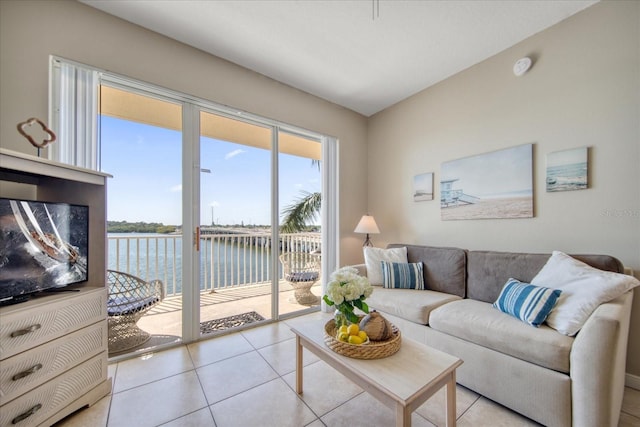 living room featuring light tile patterned flooring and a water view