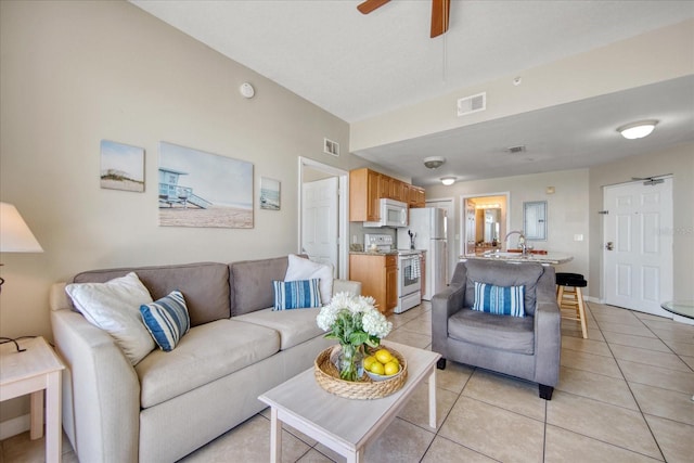 living room with ceiling fan and light tile patterned floors