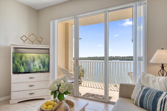 living room featuring light tile patterned floors and a water view