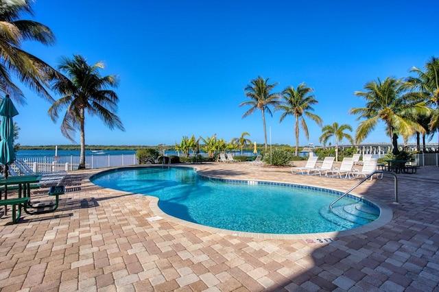 view of swimming pool featuring a patio area and a water view