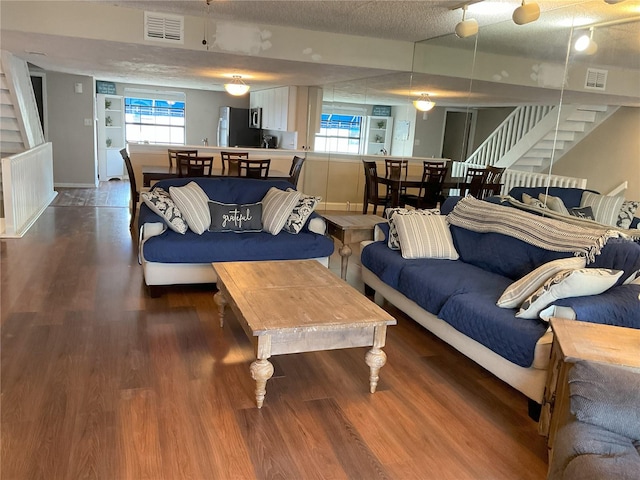 living room featuring plenty of natural light, dark hardwood / wood-style flooring, and a textured ceiling