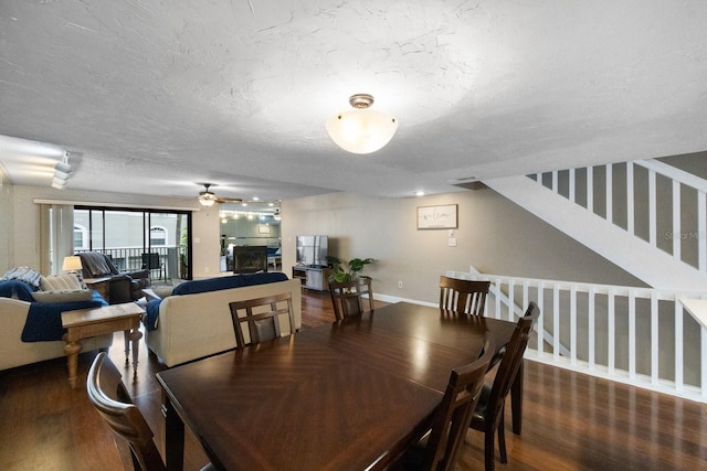 dining space featuring dark hardwood / wood-style flooring, ceiling fan, and a textured ceiling