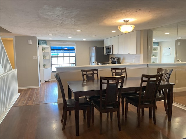 dining area with dark hardwood / wood-style floors and a textured ceiling