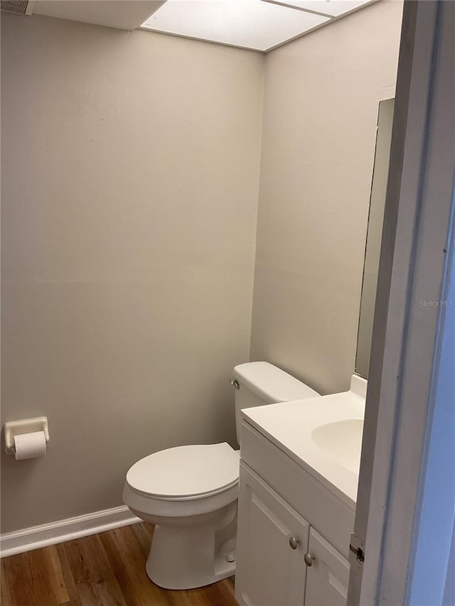 bathroom with hardwood / wood-style floors, toilet, and large vanity