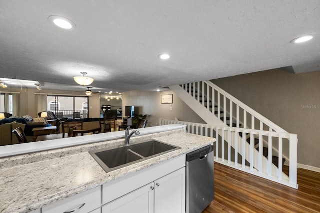 kitchen with light stone countertops, dark hardwood / wood-style flooring, white cabinetry, sink, and dishwasher