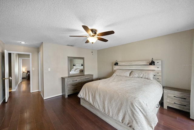 bedroom with dark hardwood / wood-style flooring, ceiling fan, and a textured ceiling