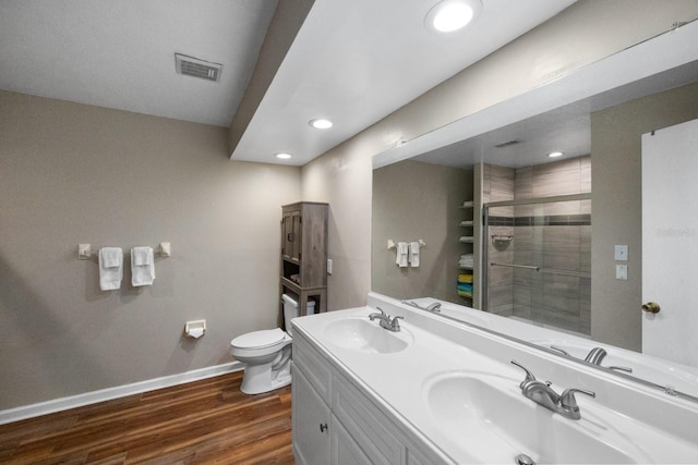 bathroom with hardwood / wood-style flooring, toilet, and double sink vanity