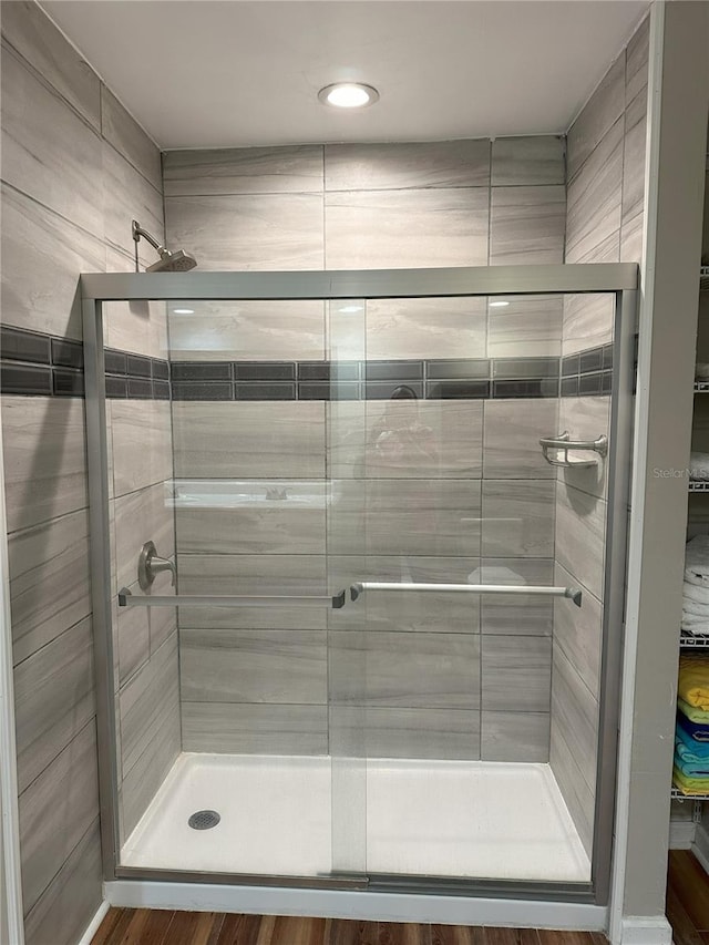 bathroom featuring walk in shower and hardwood / wood-style flooring